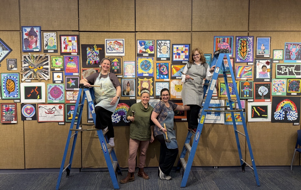 teachers posing after putting artwork together