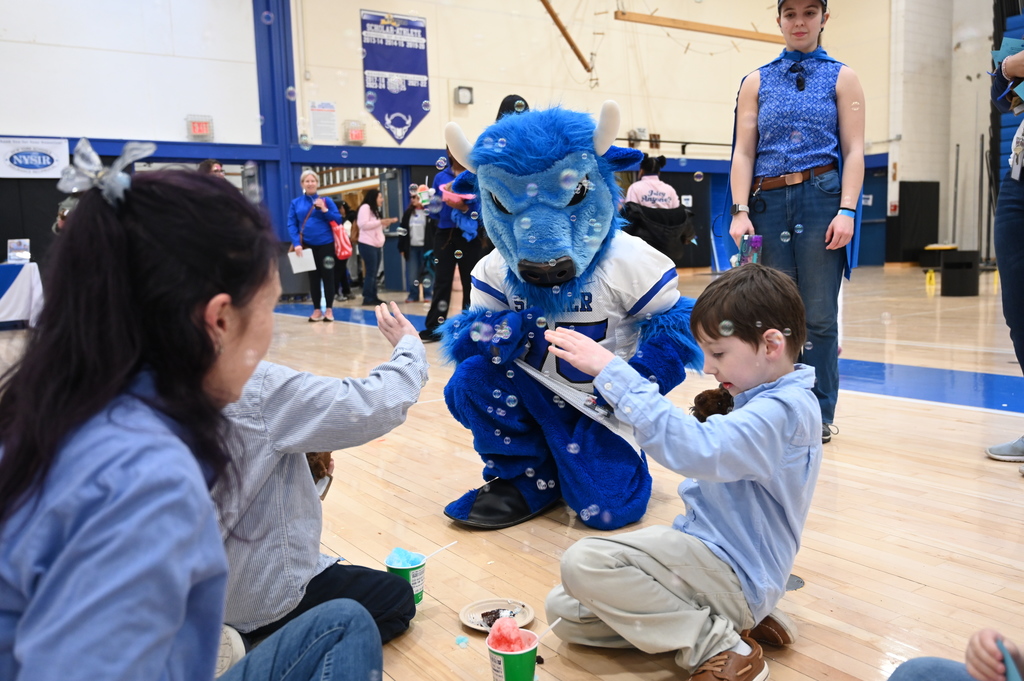 Bryson the Bison playing with student and bubbles