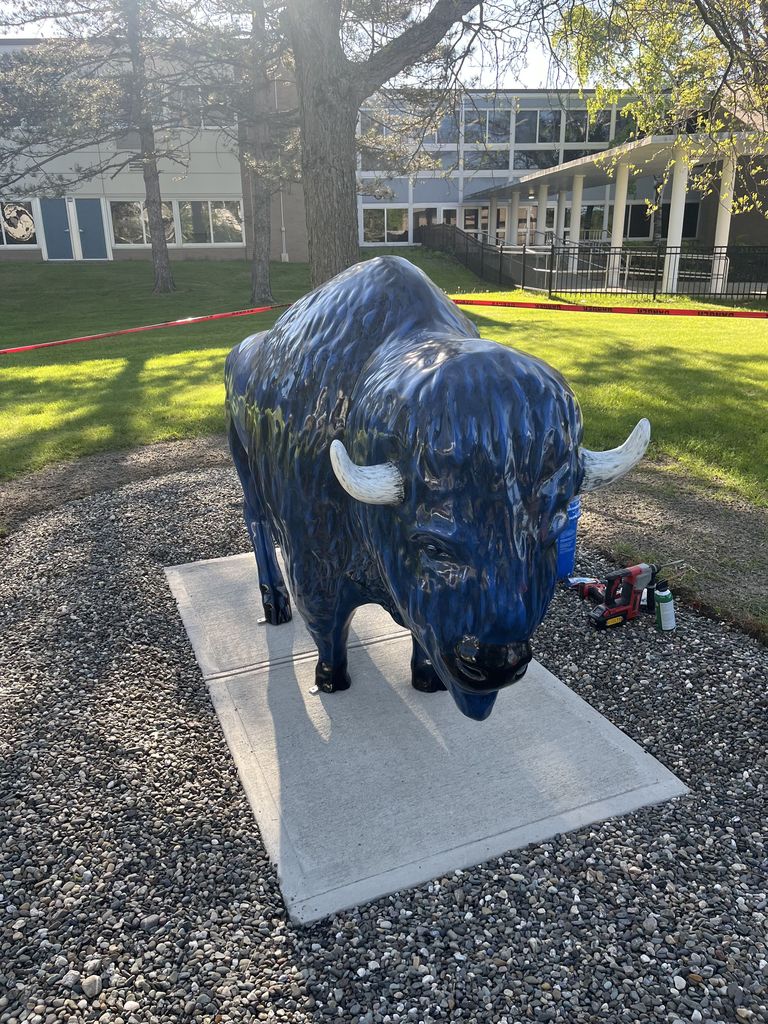An image of a large blue bison on a slab of concrete.