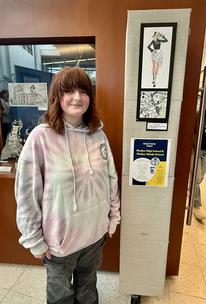 student standing next to her artwork