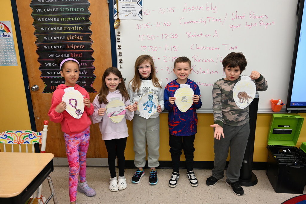students showing off artwork, three girls and two boys