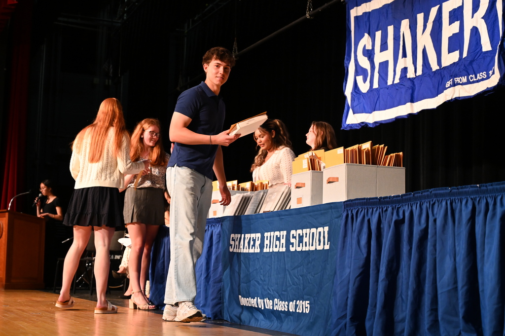 A student smiles as he walks off stage with an award.