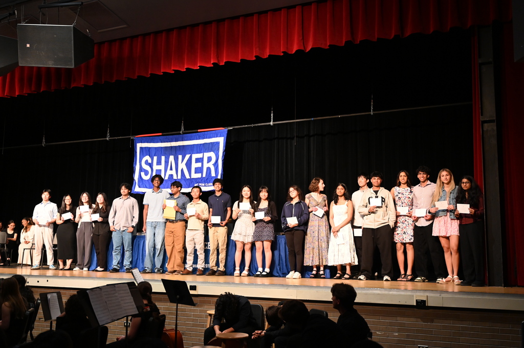 A large group of students stands on stage after being honored.