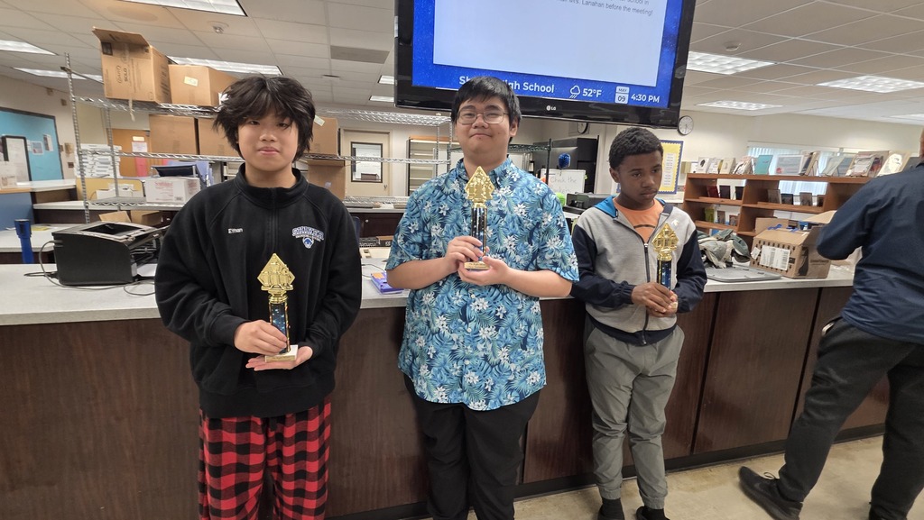 Three students pose with trophies from their wins at the Inaugural Shaker High School Chess Tournament.