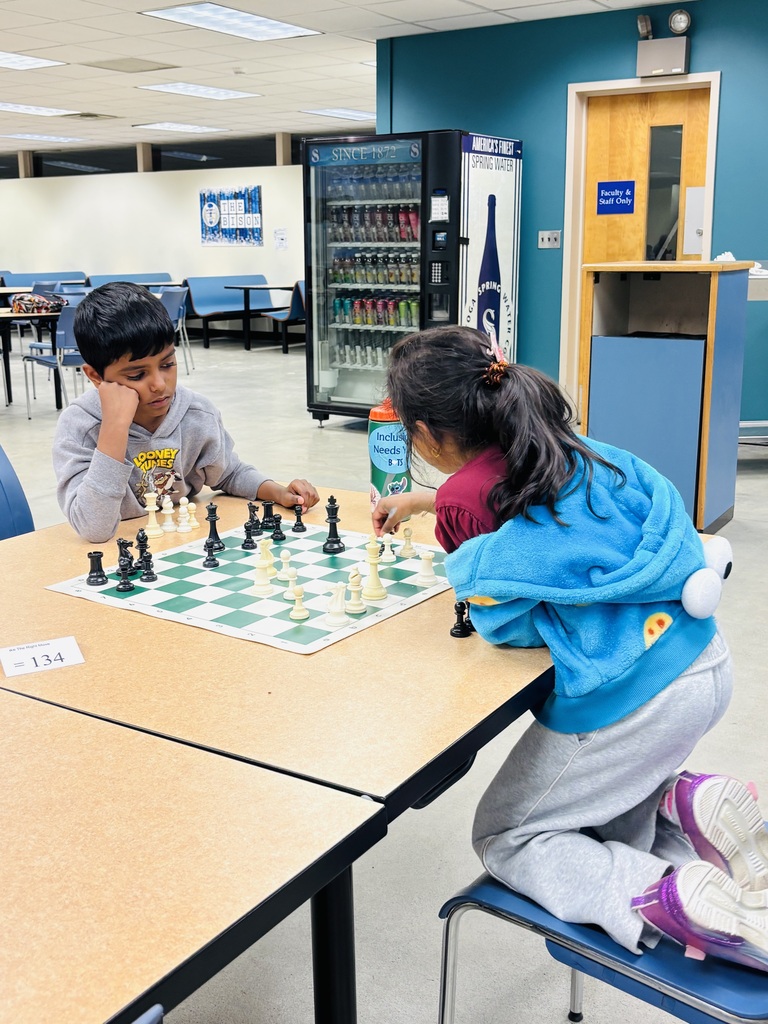Two students playing chess against one another.