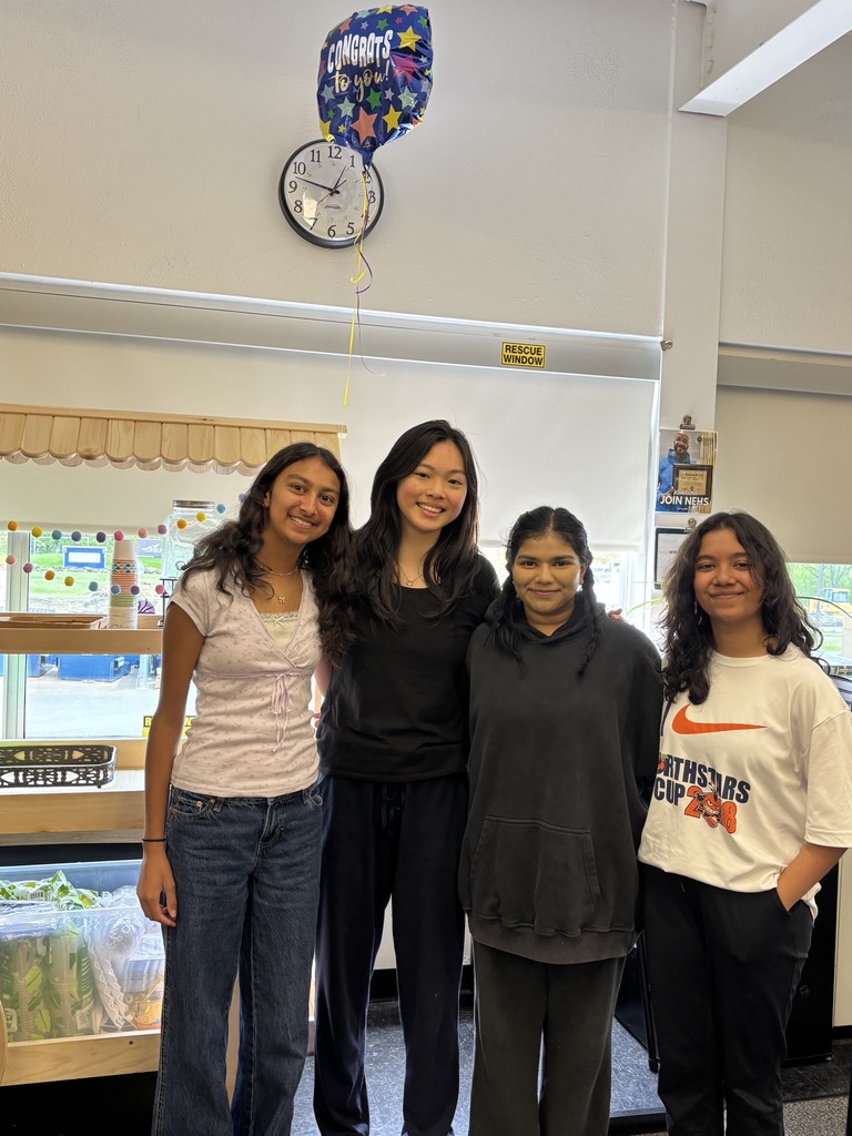 Four student award winners pose together in a classroom.