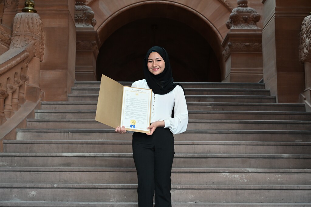 Sima stands on the Million Dollar Staircase with her state resolution.