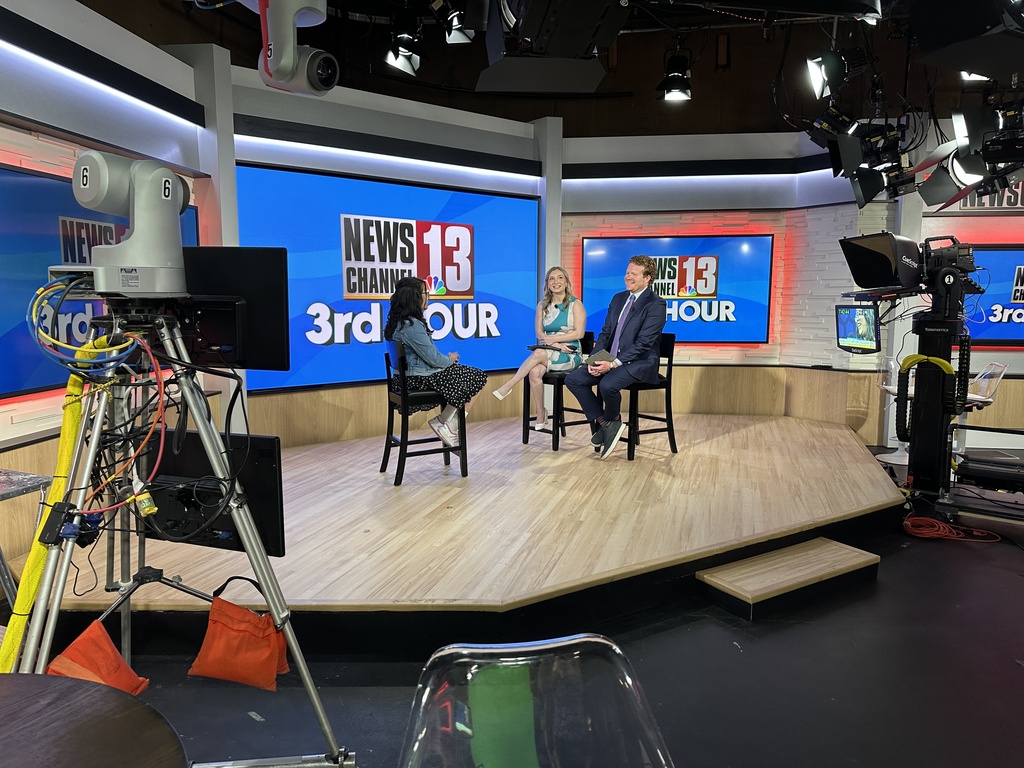 A wide shot of the WNYT NewsChannel 13 set as Krrisha gets interviewed by morning anchors on set.
