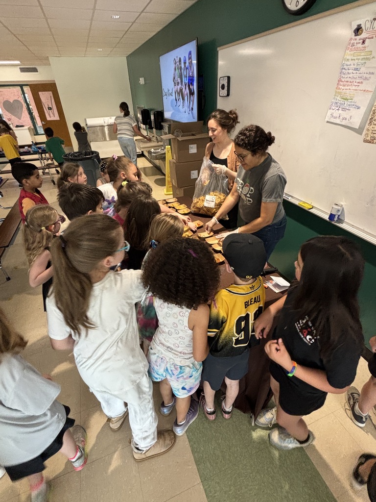 Students surround a table as Community Food Works representatives hand out samples of tortilla chips and salsa.