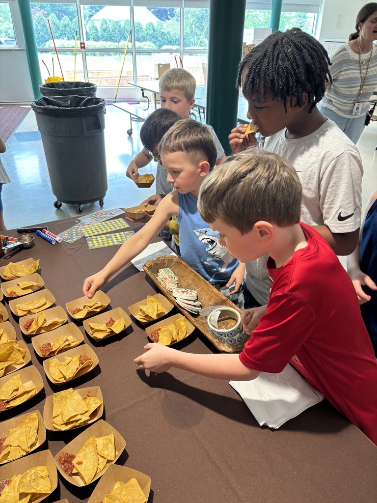 Students reach for samples of tortilla chips and salsa during lunch.