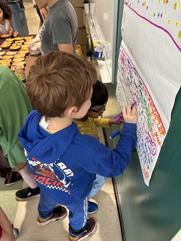 A student leaves a comment in marker on a paper on the wall.