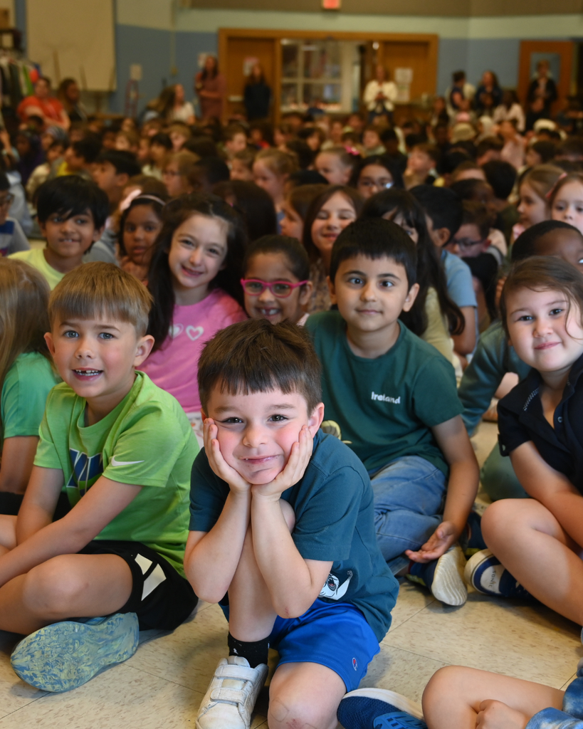 Blue Creek first graders smile watching Mr. Turcio's hairuct