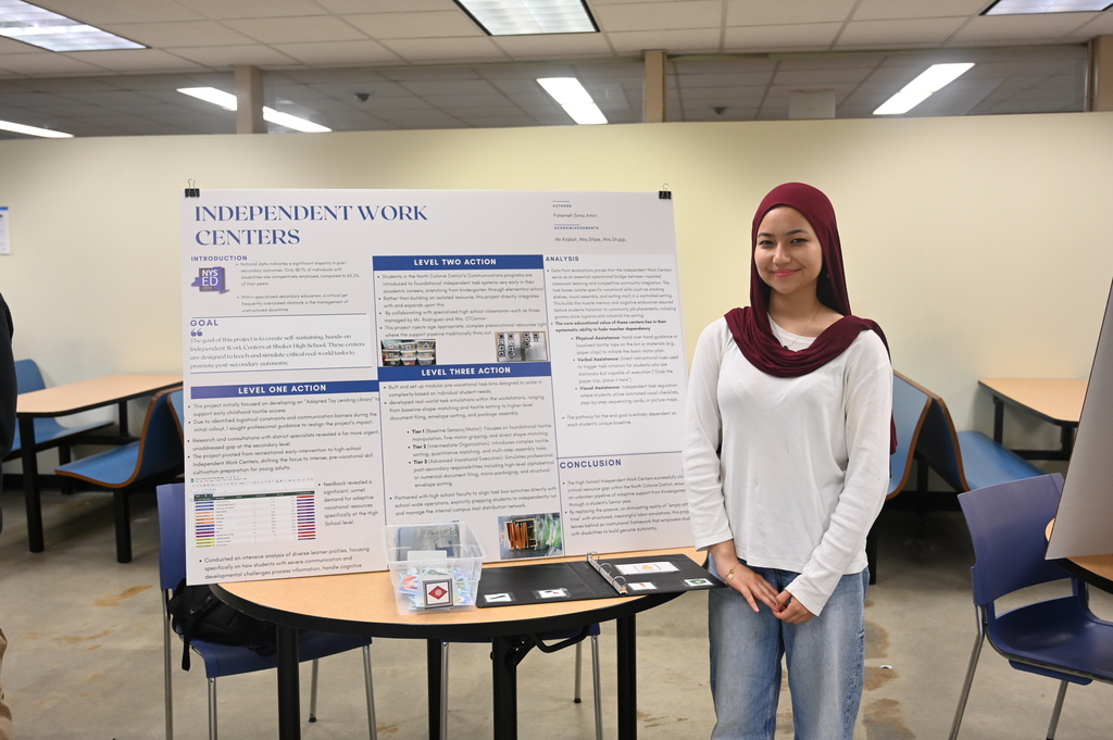 student posing with a sign stating independent work centers