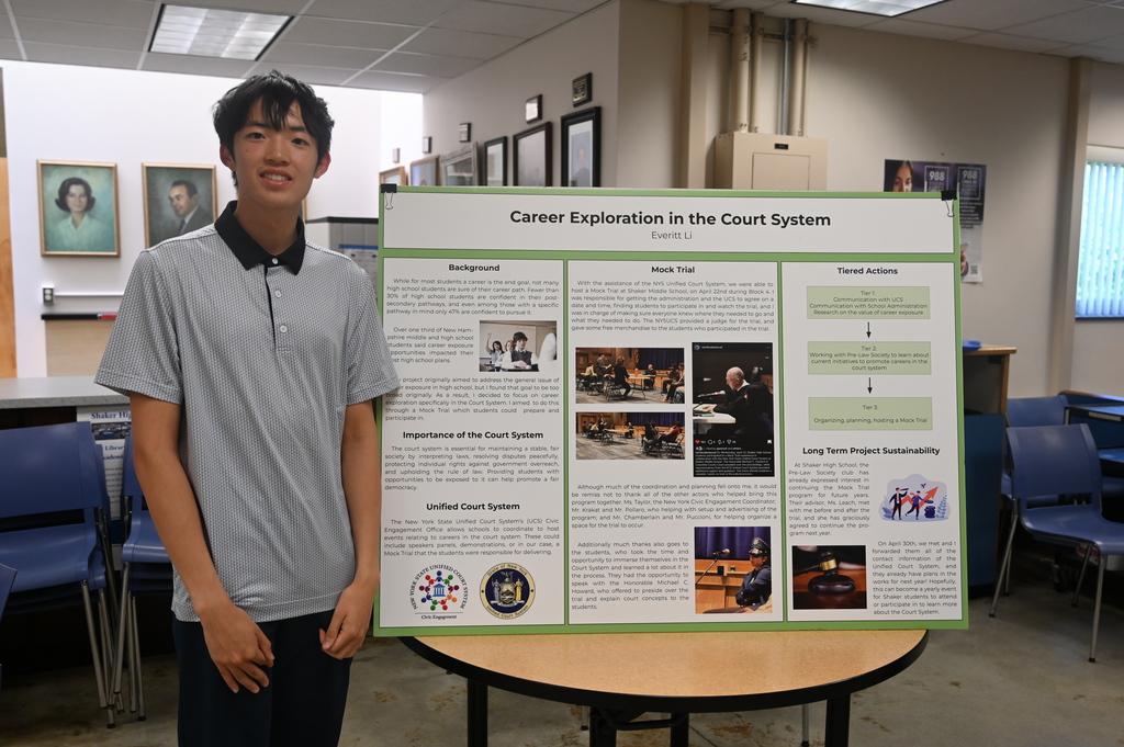 student posing with a sign stating career exploration in the court system