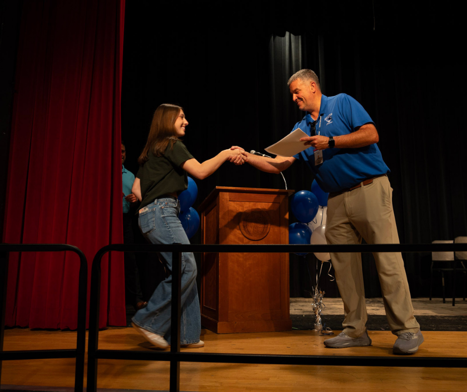 Senior shakes Athletic Director, Sean Colfer's hand
