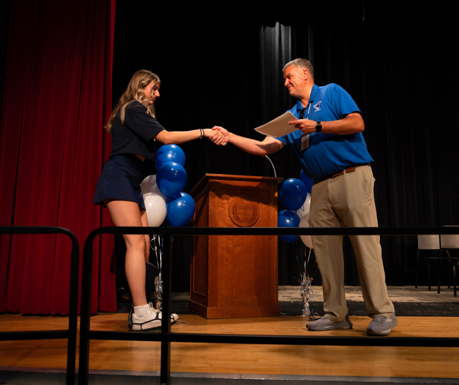 Senior shakes Athletic Director, Sean Colfer's hand
