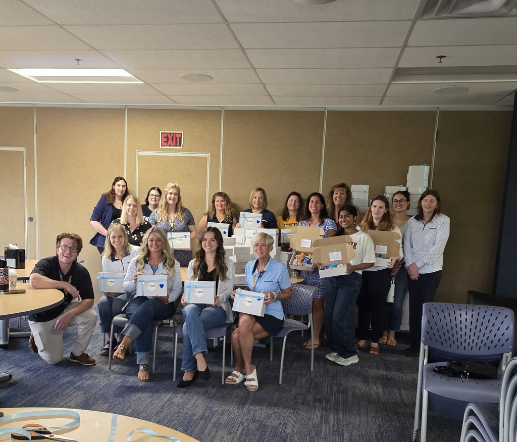 More than a dozen Sunmark employees pose with a Shaker student and the Gleeboxxes they helped put together.
