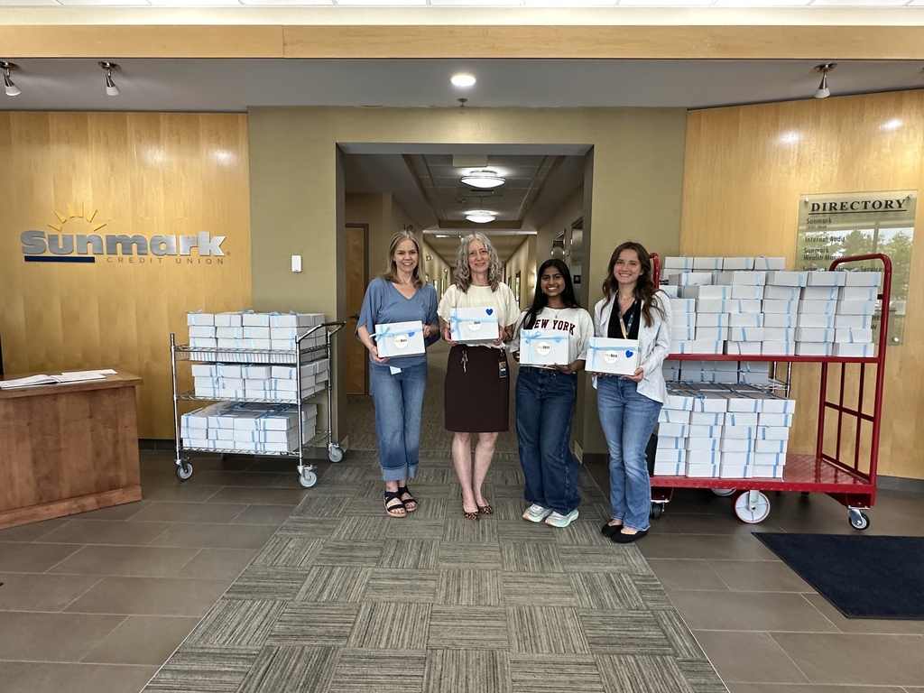 Shreya and three employees stand together with the 240 boxes going to North Colonie CSD.