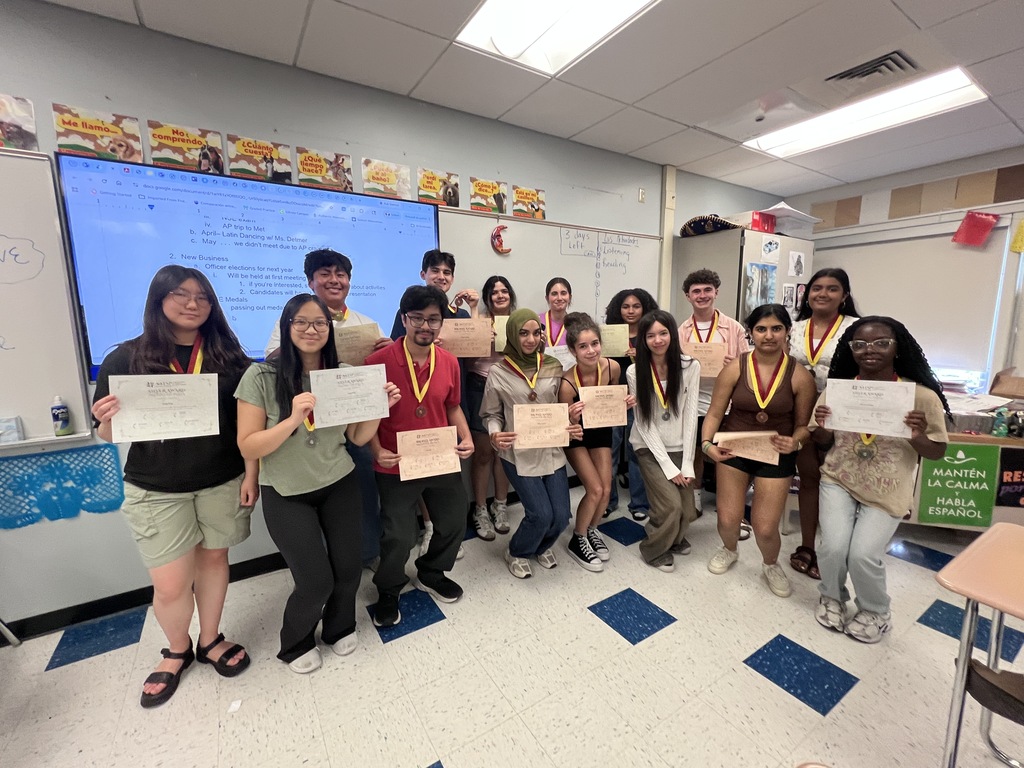 A group of students pose with certificates for their achievement on the National Spanish Exam.