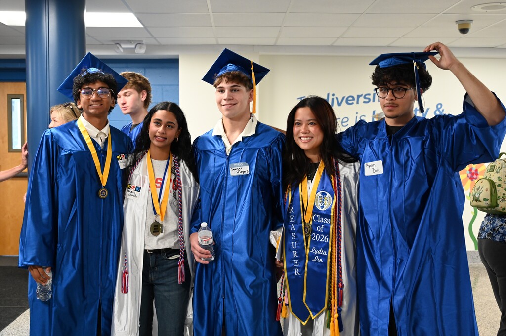 Graduating seniors pose together inside their former elementary school.