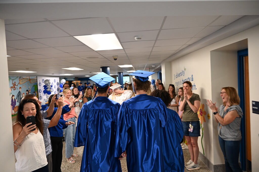 Graduating seniors enter the lobby to cheers from their former teachers and family members.