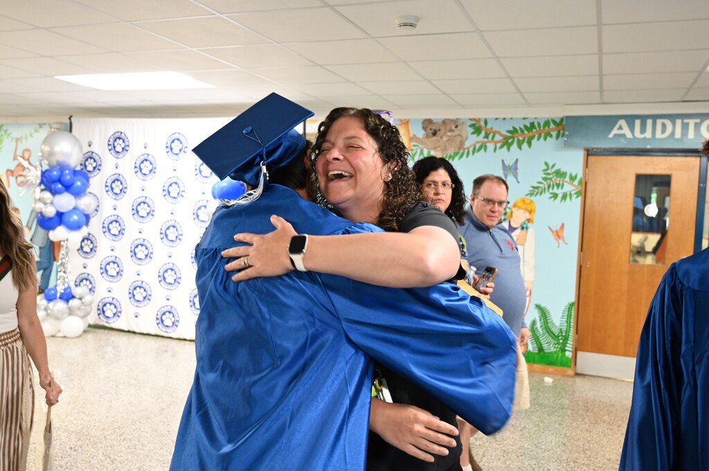 A P.E. teacher hugs one of her former students who is graduating this year.