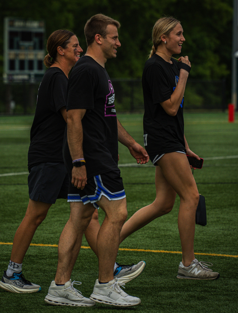 Coaches of the seniors walk on the field.