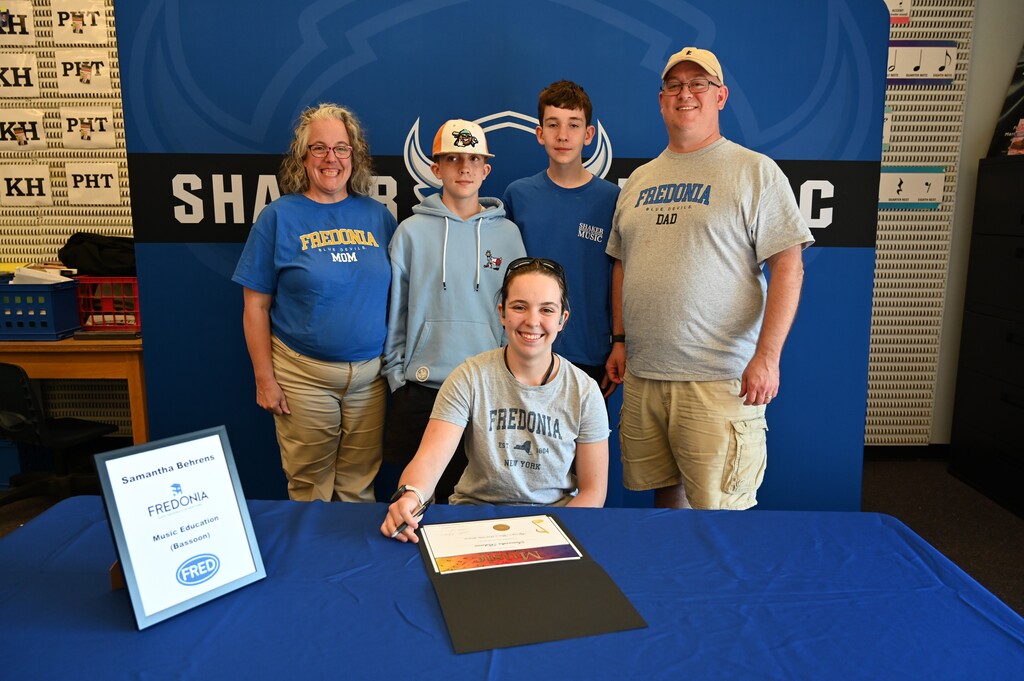 A student poses with their family after signing.