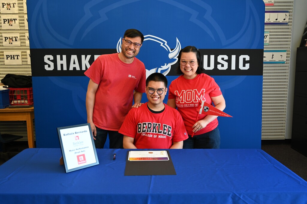 A student poses with their family after signing.