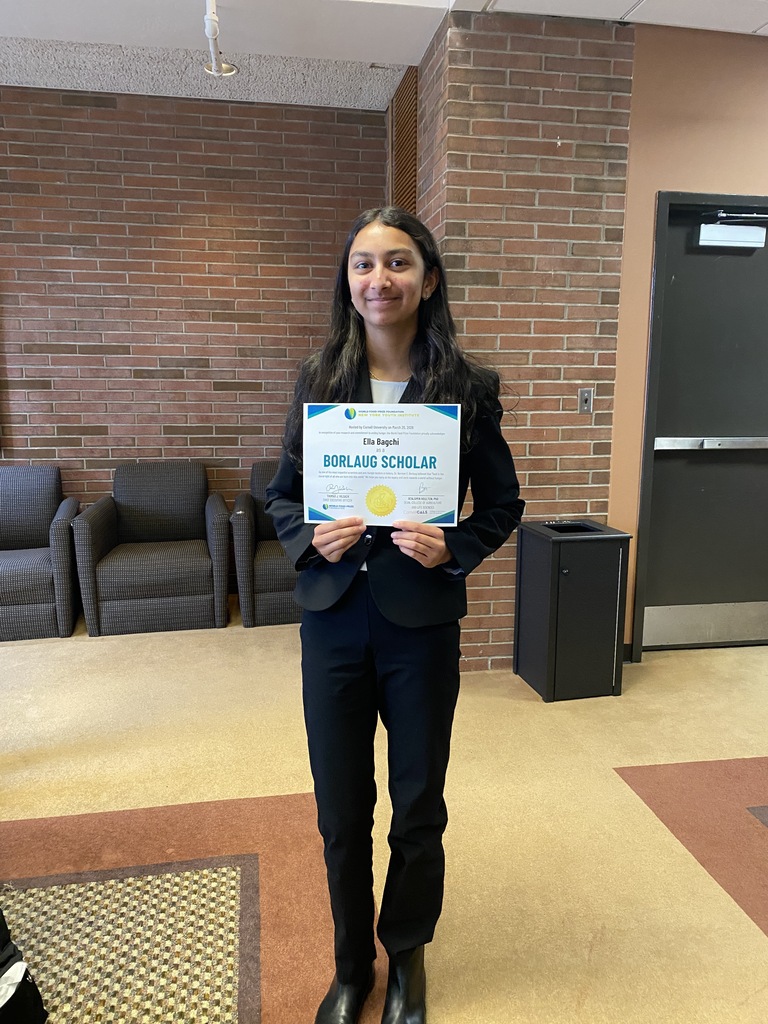 Ella holds poses with her certificate as a Borlaug Scholar.