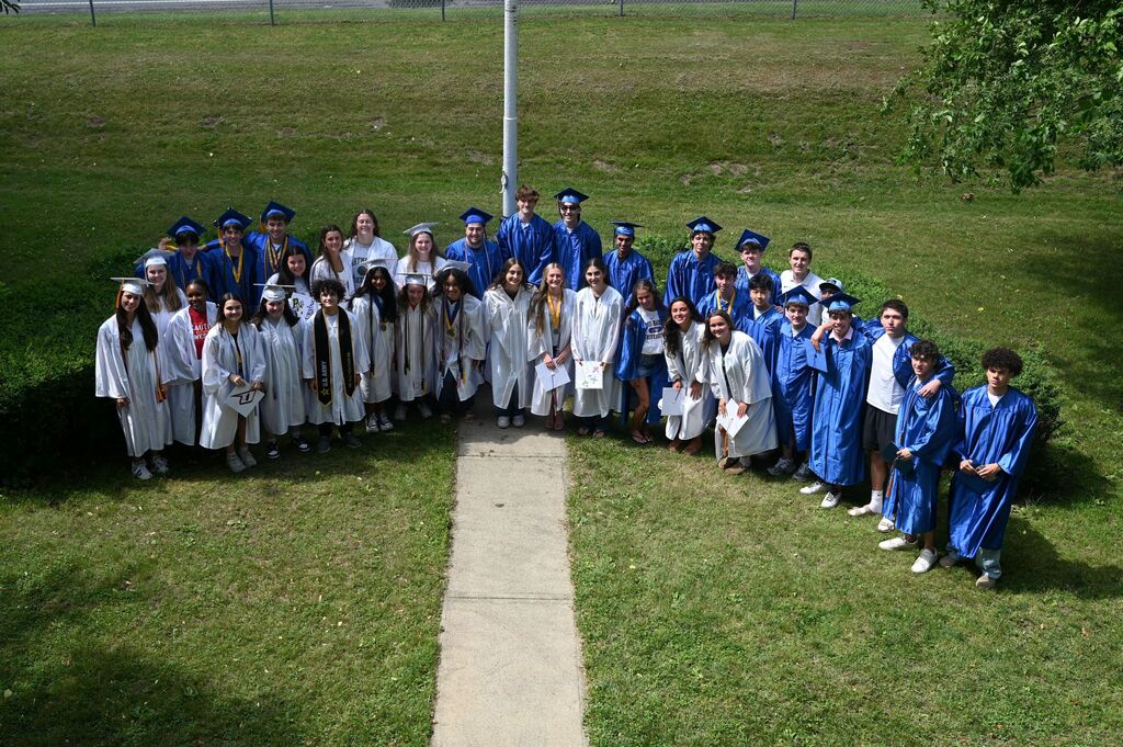 Congratulations class of 2026, students posing outside a window