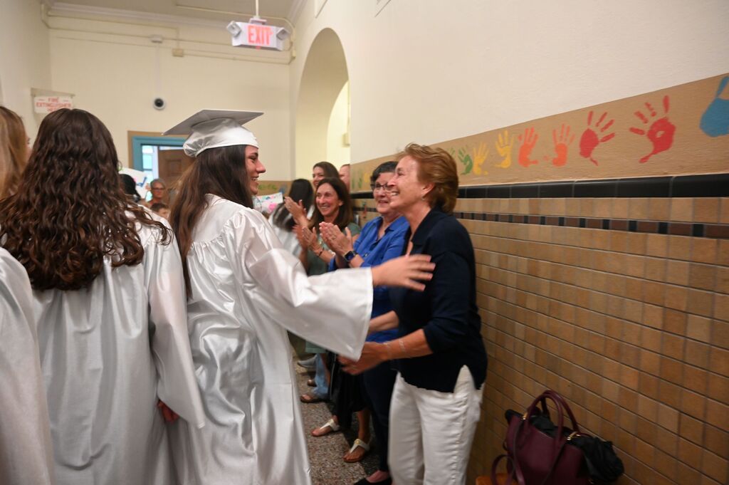 loudvonville students waiting for the seniors to walk through, student greeting former teacher