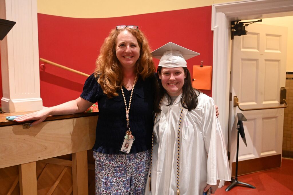 student posing with her teacher