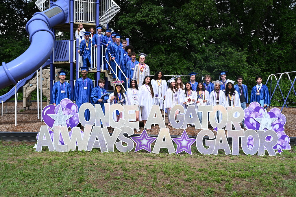 Shaker seniors standing in front of Once a Gator, Always a Gator sign on Southgate playground