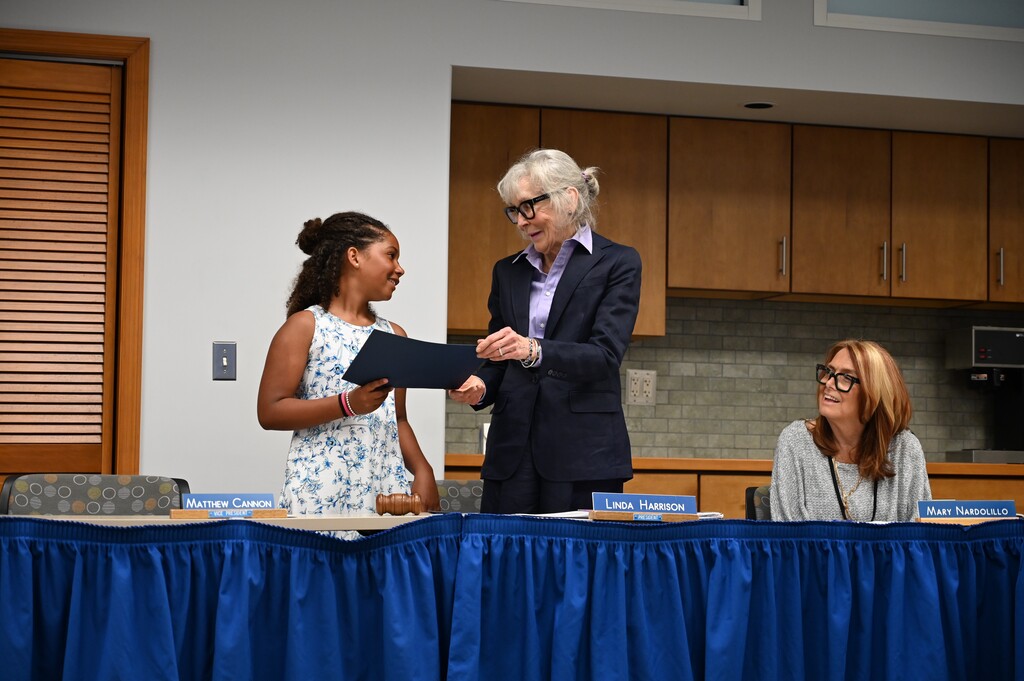 Harper receives a certificate from Board of Education President Linda Harrison.