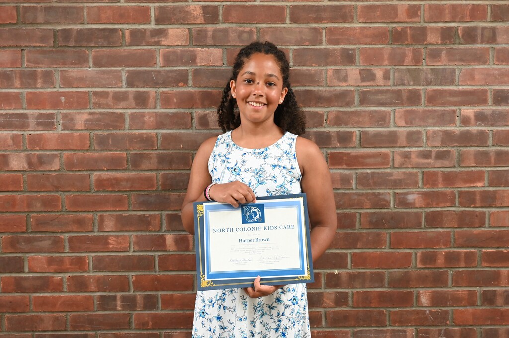 Harper poses with her certificate as a Kids Care recipient.