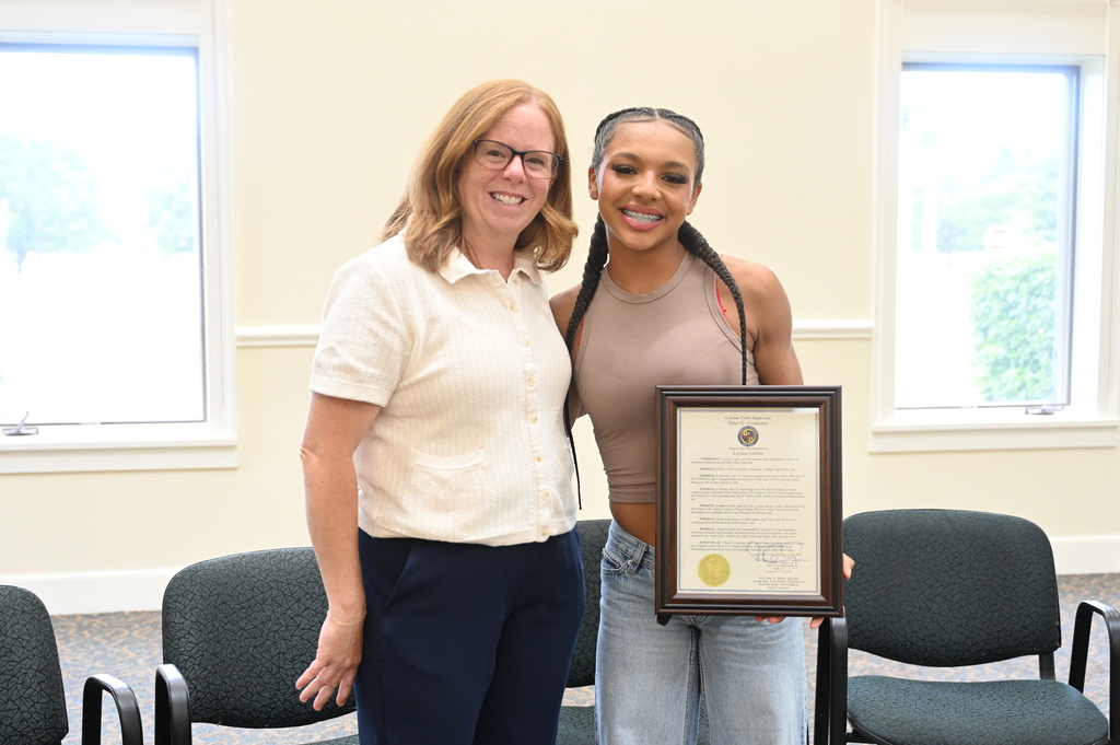 Freshman Lily Griffin and Coach DeBellis smile with the proclamation for Lily's achievements.