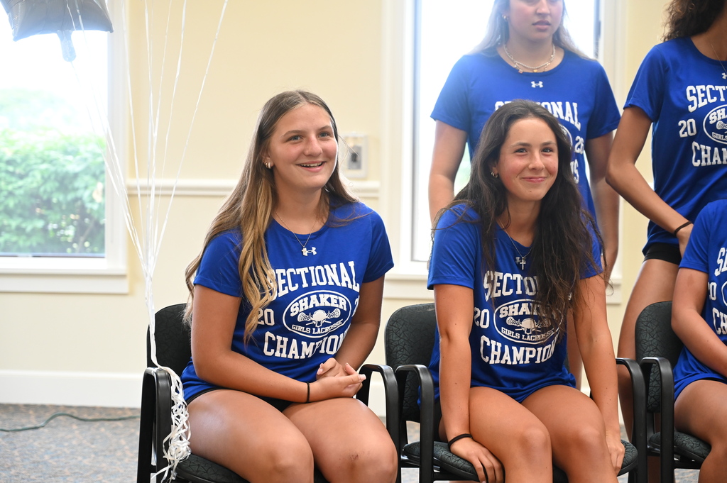 Two Shaker players smile seated in chairs next to one another.