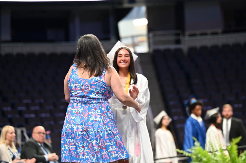 Graduate walks across stage to hug mom and recieve diploma