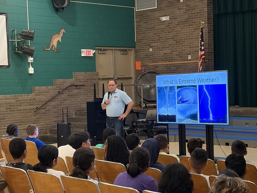 Paul standing in front with a screen reading extreme weather