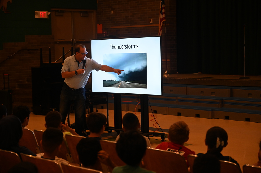 Paul standing in front with a screen reading thunderstorms