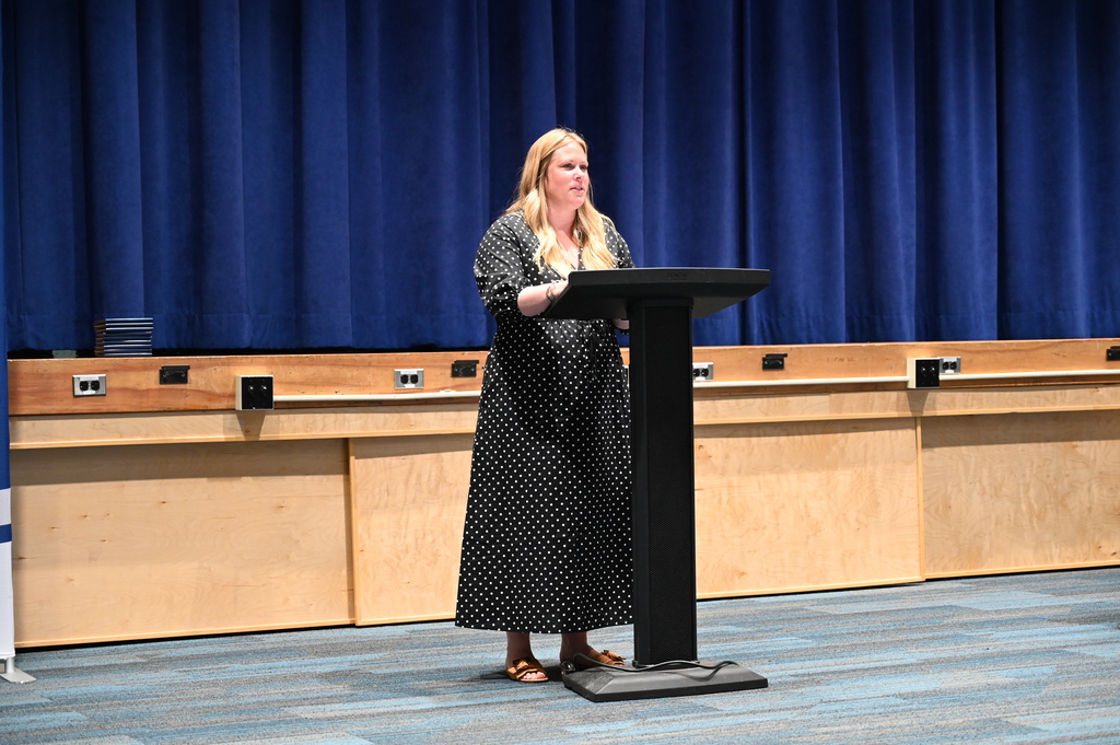 Summer School Principal Morgan Flynn speaks from a podium.