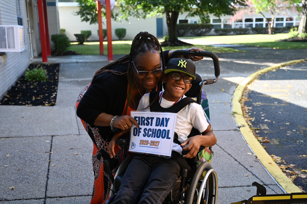 Student and educational aide smile for first day of school