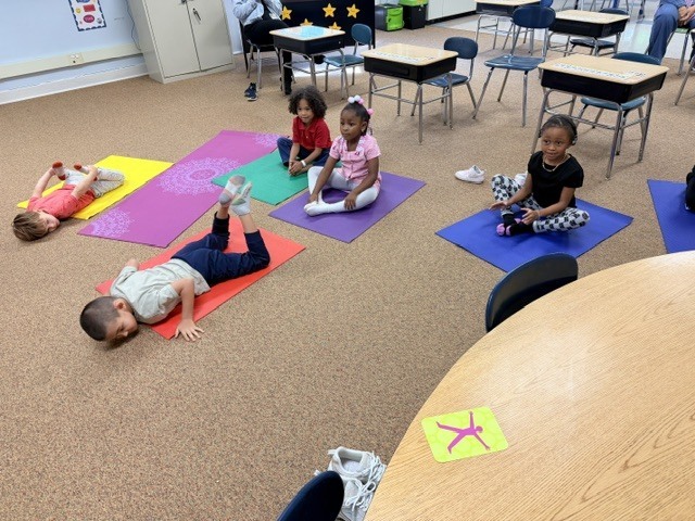 students practicing yoga poses on a yoga mat