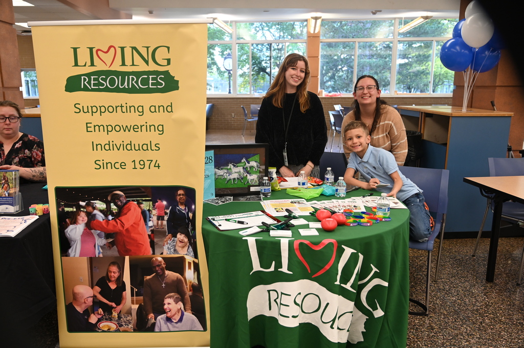 group of three people posing for a photo in front of a table, two females one young male child