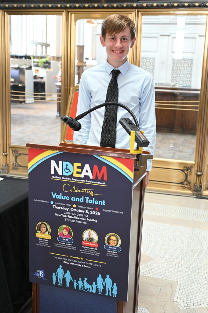 Student David Terrell stand behind the podium smiling.