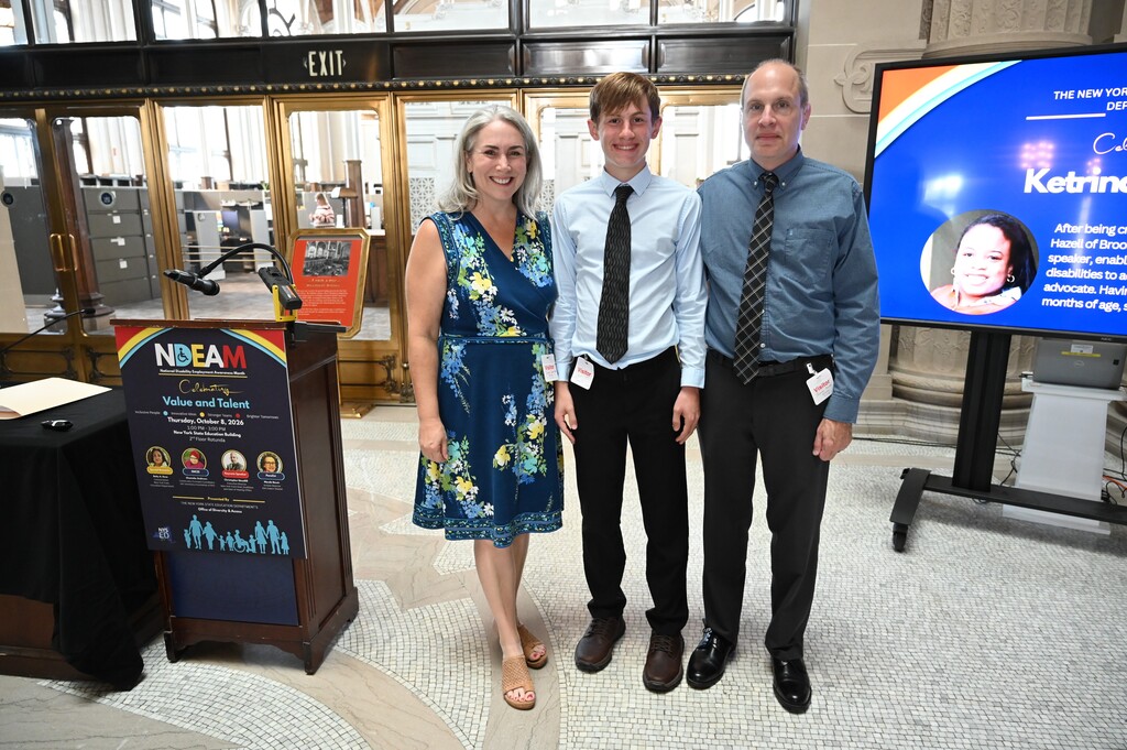 David stands in between his proud parents next to the podium.