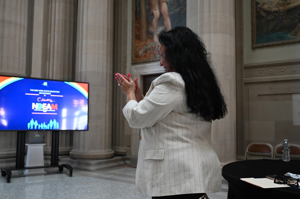 NYSED Commissioner Betty Rosa stands and applauds David.