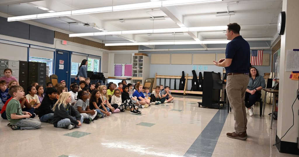 Matt Mackie explaining what it means to be a meteorologist to third grade