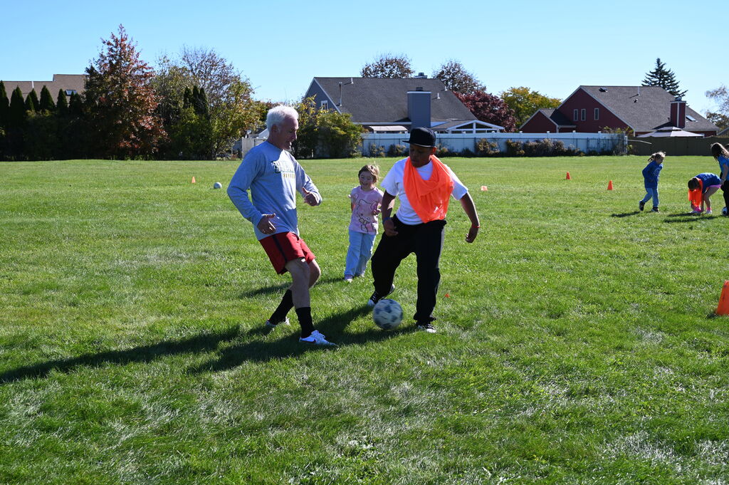 ed placke playing soccer with a student